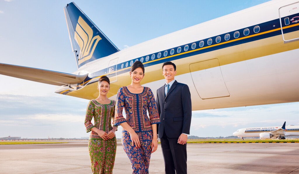 Personas frente a avión de Singapur air.